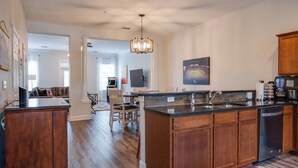 A modern kitchen with wooden cabinets, a granite countertop, and a built-in dishwasher.