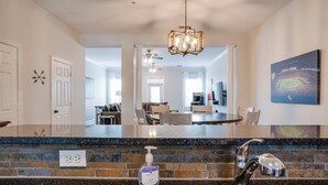 A kitchen with a granite countertop, a built-in sink, and a ceiling fan.