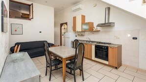 A compact kitchen with a dining area, a built-in stove, and a microwave.