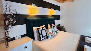 A bedroom with a wooden ceiling, a bed with a green upholstered headboard, bedside tables, and wall-mounted lights. - Quinta Vale Salgueiro (Carragozela)