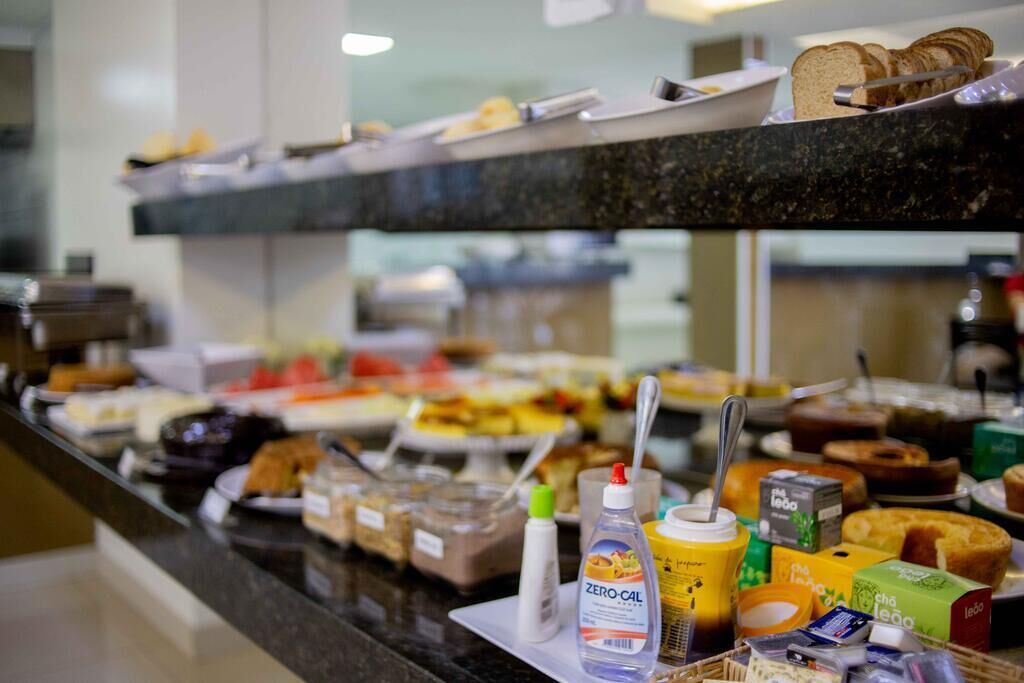Balcão de buffet com diversos alimentos e acompanhamentos.