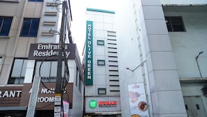 A hotel named "Emirates Residency" with a sign for "HOTEL OLIVE GREEN" and an "IFTHAR" restaurant sign. - Olive Green Hotel (Kanayannur)