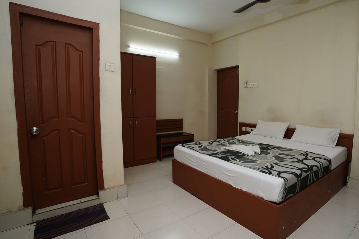 A bedroom with a bed, a desk, a chair, and a wardrobe.