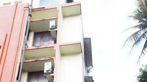 A multi-story building with a sign for "ROOMS OLIVE GREEN" indicating a hotel or lodging facility. - Olive Green Hotel (Kanayannur)