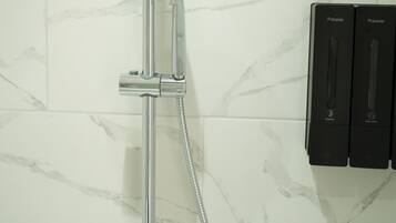Una ducha moderna con cabezal de ducha de lluvia, un cabezal de ducha de mano y un rociador manual.