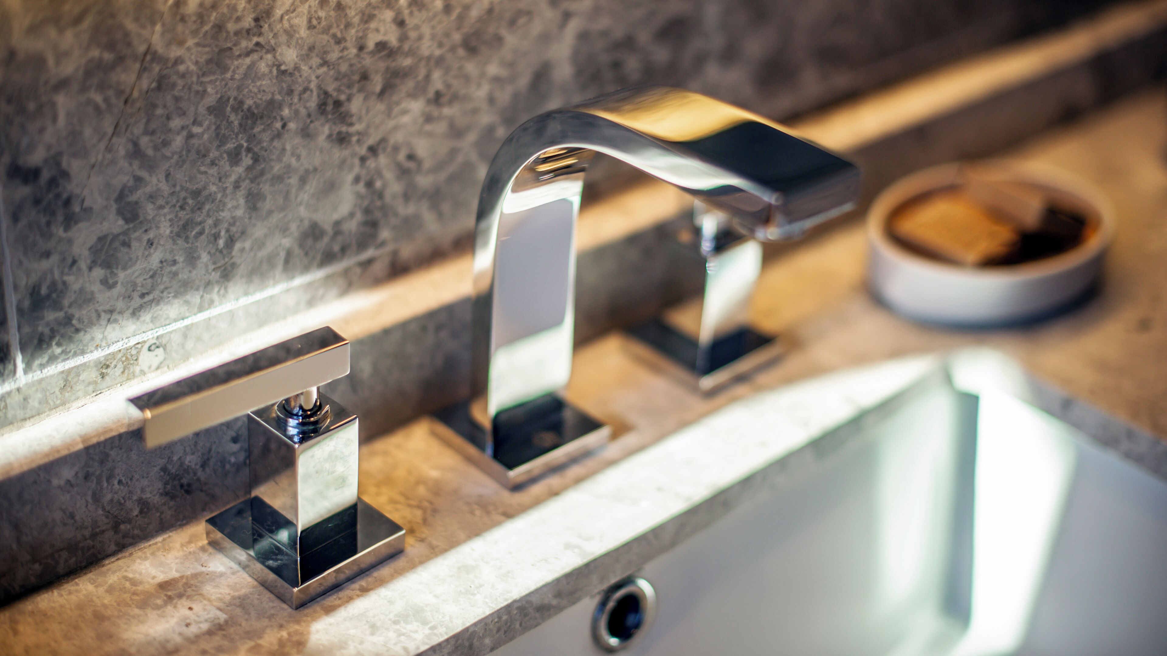 A modern bathroom with a sleek, metallic faucet and a rectangular sink.