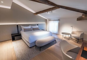 A modern bedroom with a large bed, bedside tables, a chair, and a small table. - La Villa des Vignes (Saint-Émilion)