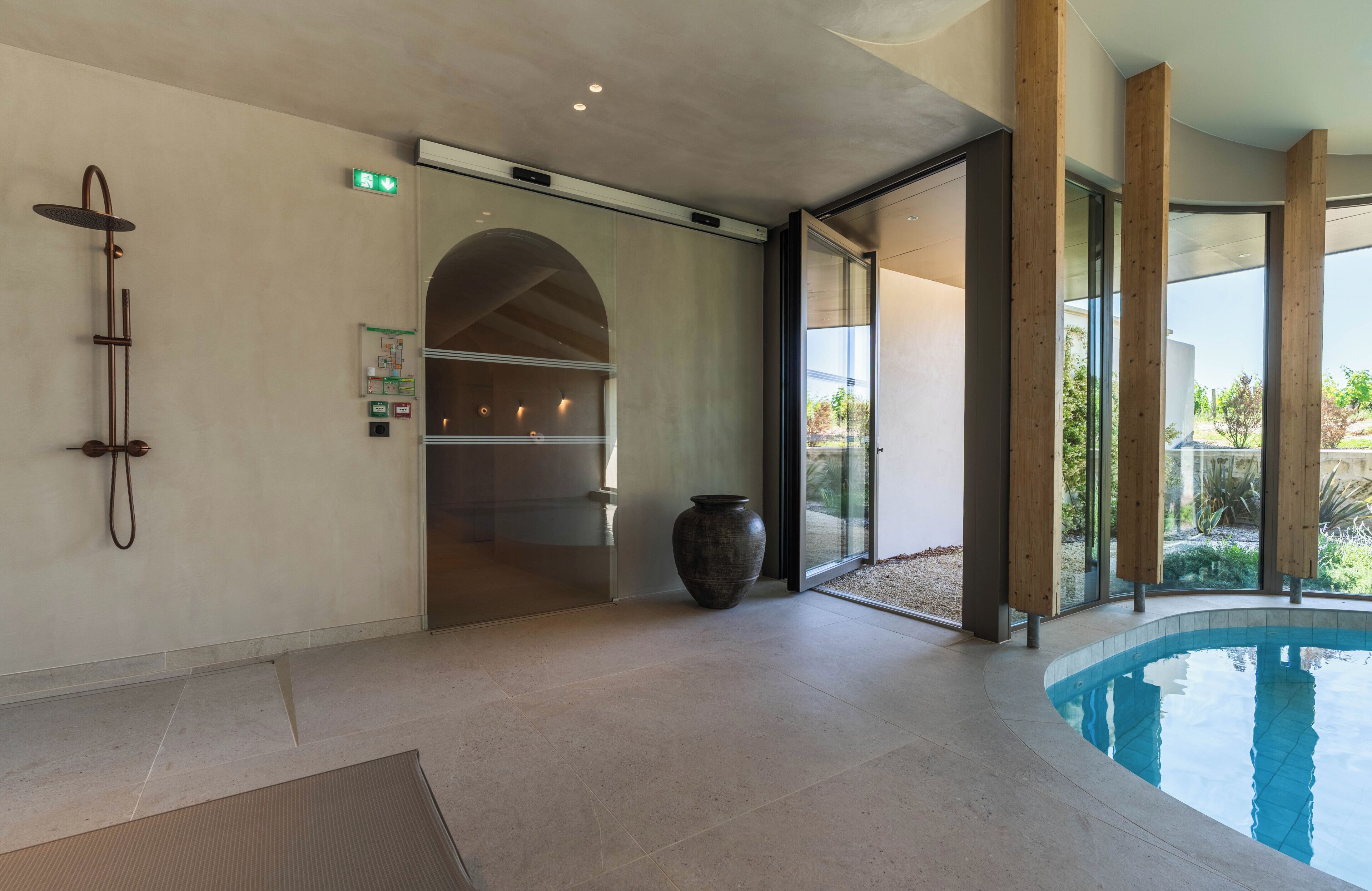 A modern bathroom with a shower, a large vase, and a pool area.