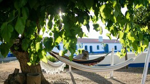 A hammock under a tree with a building in the background. - Sunset Yellow Villa, Avis, Portalegre (Vale do Freixo)