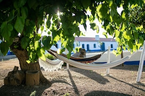A hammock under a tree with a building in the background. - Sunset Yellow Villa, Avis, Portalegre (Vale do Freixo)