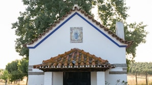 A small building with a tiled roof, a black door, and a decorative tile above the door. - Sunset Yellow Villa, Avis, Portalegre (Vale do Freixo)