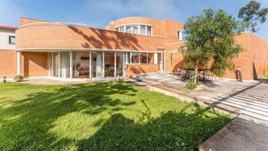 A two-story brick house with a covered patio and a small garden. - Esmoriz's golden hour with pool (Esmoriz)