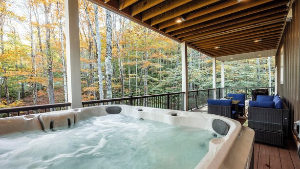 A hot tub on a wooden deck with a view of autumn trees. - NF72: Brand New, Creekside home, 3 King Suites, Hot Tub. Firepit (Davis)