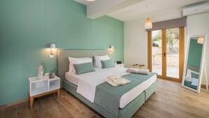 Ein Schlafzimmer mit einem großen Bett, einem Nachttisch, einer Nachttischlampe und einer Schiebetür zum Außenbereich.