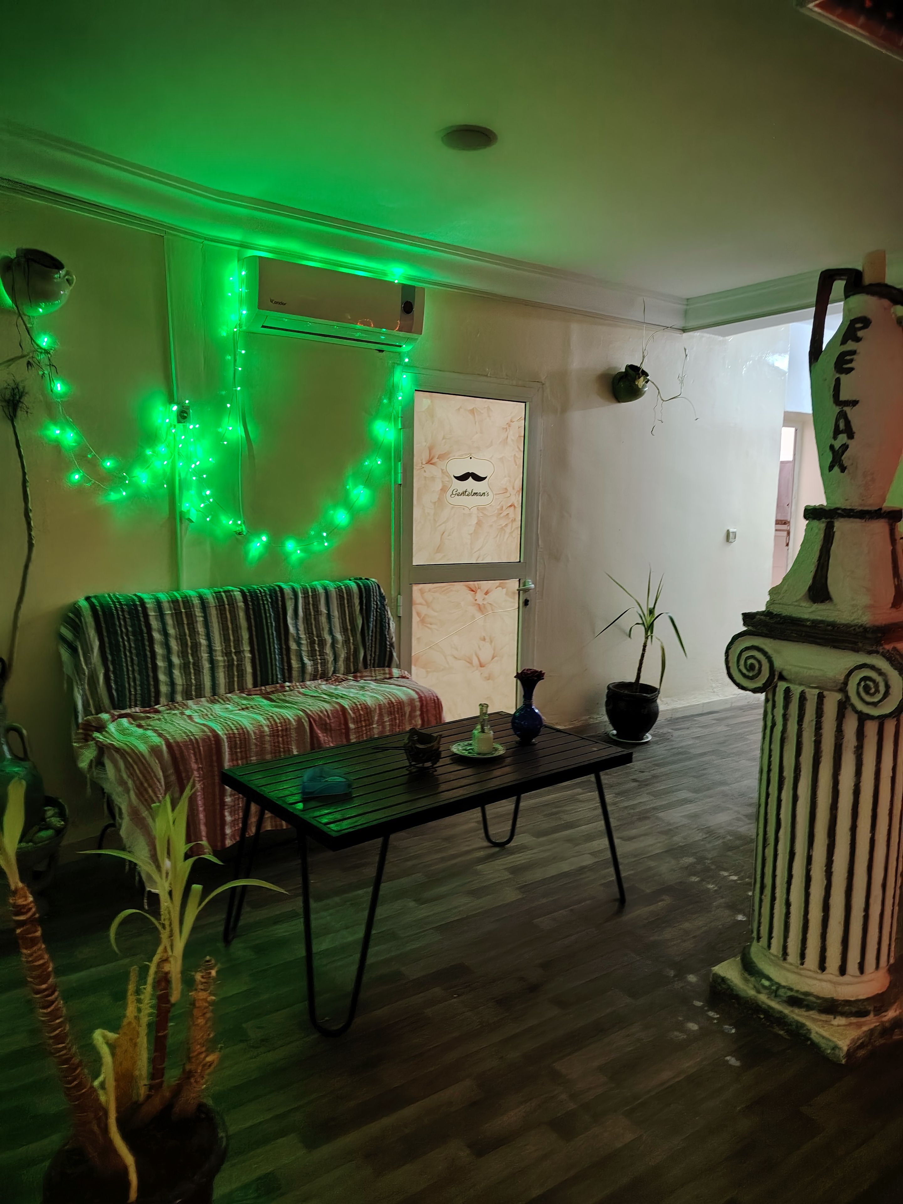 Una habitación con sofá, mesa de centro y una columna decorativa.