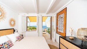 Une chambre à coucher avec un lit, des tables de chevet et une vue sur l’extérieur.