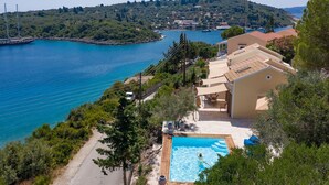 Une propriété située sur la côte, dotée d’une piscine, d’un accès routier et offrant une vue sur la mer et les collines.