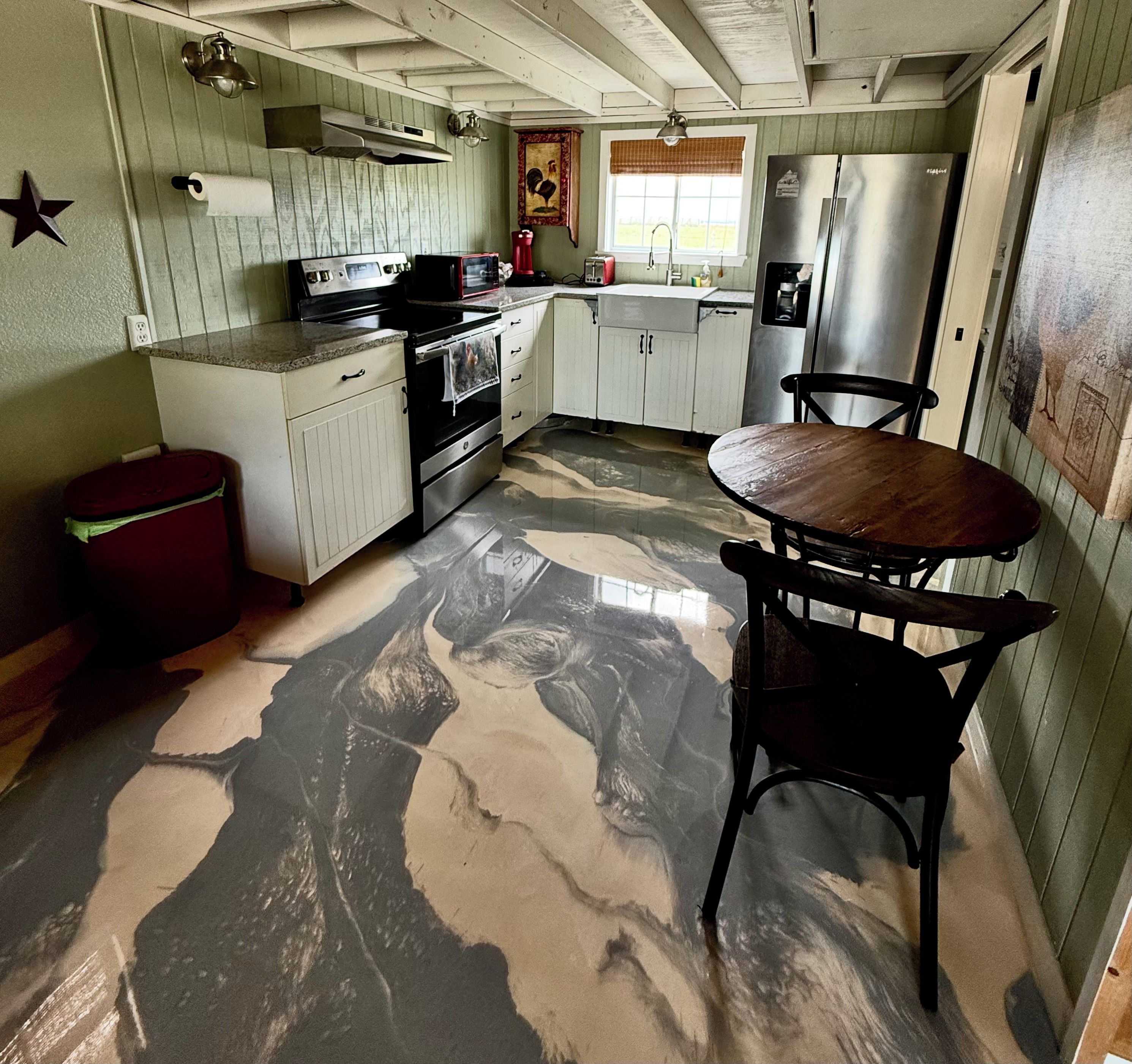 A kitchen with white cabinets, a stove, a refrigerator, and a wooden table with chairs.