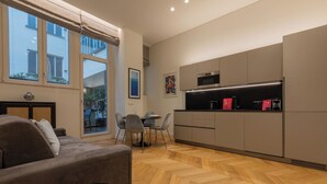 A modern kitchen with a dining area, a sofa, and large windows. - Prestige Apartment Via Roma by Wonderful Italy (Turin)
