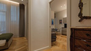 A modern bedroom with a bed, a dresser, and a dining area with chairs and a table. - Prestige Apartment Via Roma by Wonderful Italy (Turin)