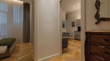 Un dormitorio moderno con cama, cómoda y zona de comedor con sillas y mesa.