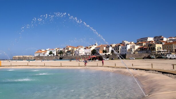 A coastal town with a clear sky, a sandy beach, and a water fountain. - Coral Beach Apartment (Figueira da Foz)