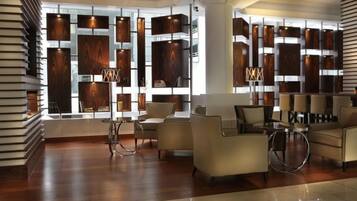 A modern lobby with a wooden wall feature, seating area, and a floor lamp.