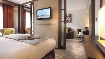 Una habitación de hotel con cama, televisión, escritorio y una silla.