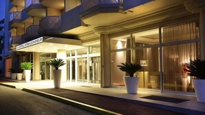 A hotel entrance with a modern design, featuring large glass doors and potted plants. - AC Hotel by Marriott Ambassadeur Antibes - Juan Les Pins (Juan-les-Pins)