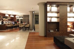 Een hotellobby met een bar, zitplaatsen en een open haard.