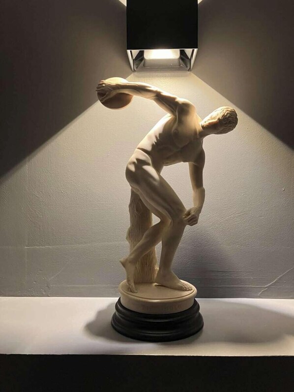Una escultura clásica de un lanzador de disco sobre un pedestal.