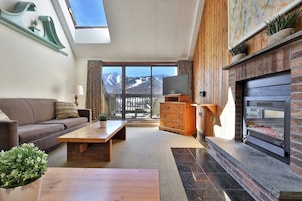 Una sala de estar moderna con sofá, mesa de centro y chimenea.
