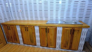 A kitchen with wooden cabinets, a stainless steel sink, and a patterned backsplash.