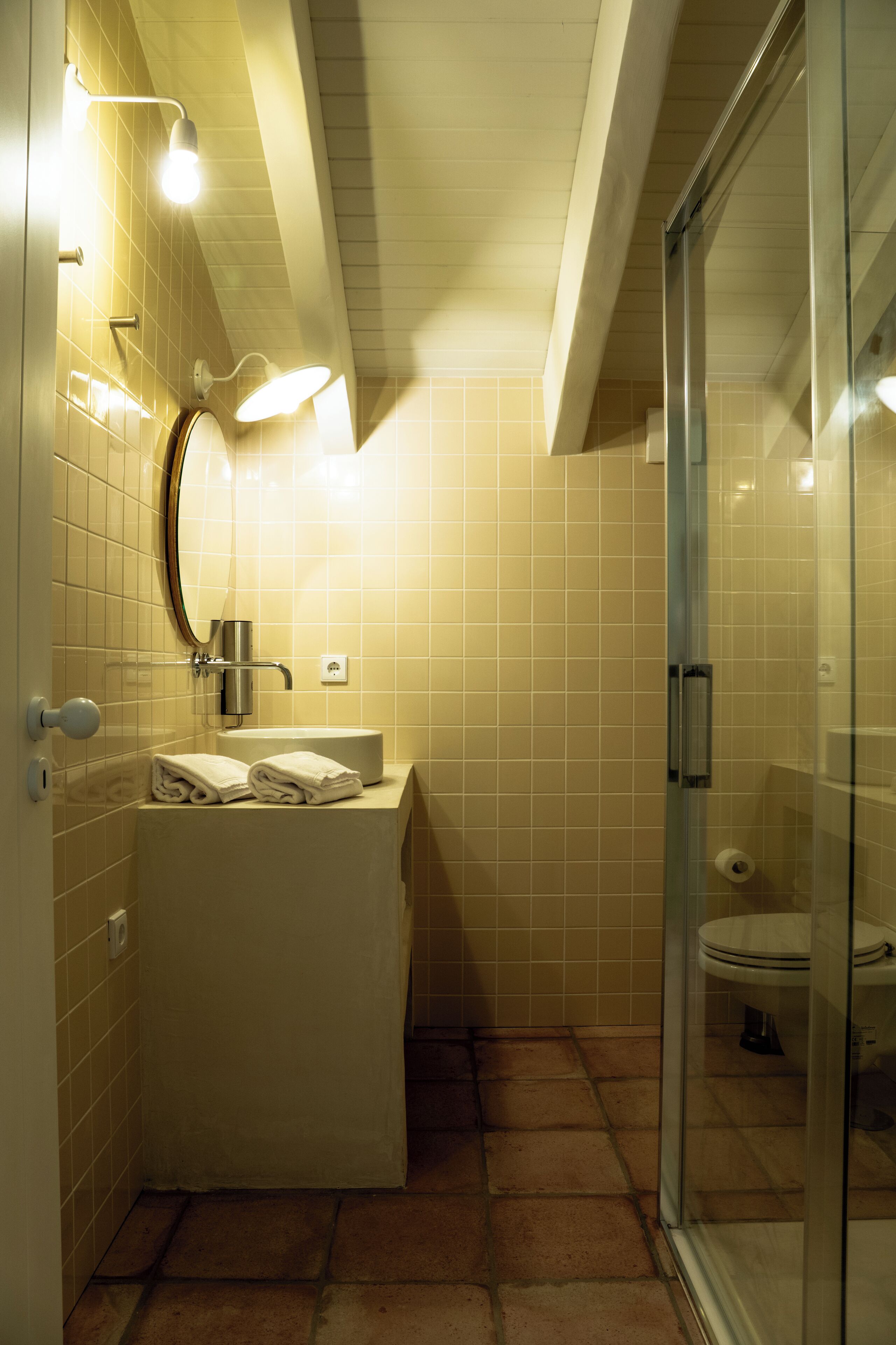 Une salle de bain avec une douche à parois de verre, un lavabo avec une serviette et des toilettes.