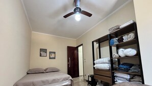 A bedroom with two beds, a wardrobe, and a ceiling fan. - Apartment 57, Air Conditioning, Sea View, WiFi, Parking Space, Complete. (Praia Grande)