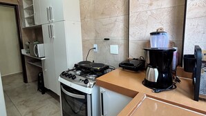A kitchen with a stove, oven, microwave, and cabinets. - Apartment 57, Air Conditioning, Sea View, WiFi, Parking Space, Complete. (Praia Grande)