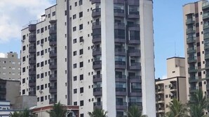 A multi-story residential building with balconies, a flat roof, and a clear sky. - Apartment 57, Air Conditioning, Sea View, WiFi, Parking Space, Complete. (Praia Grande)