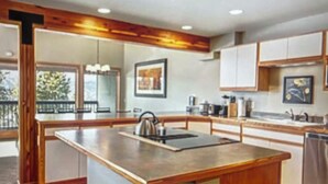 Una cucina moderna con isola centrale, mobili in legno e un'ampia finestra che permette l'ingresso di luce naturale.