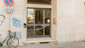 A building entrance with a no parking sign, a bicycle, and a door with glass panels. - GuestHost - Cozy 47 sqm apartment, with modern furniture, located on the third floor of a building with lift (NOT suitable for disabled people - some steps to access), able to comfortably accommodate up to 3 people. The property constitutes the ideal sta (Florence)