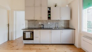 A modern kitchen with white cabinets, a built-in oven, and a window with a green blind. - GuestHost - Cozy 47 sqm apartment, with modern furniture, located on the third floor of a building with lift (NOT suitable for disabled people - some steps to access), able to comfortably accommodate up to 3 people. The property constitutes the ideal sta (Florence)