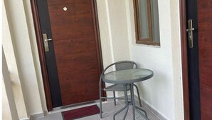A hallway with a wooden door, a glass table, and a chair. - Tranquil bed & breakfast with AC in Zugdidi (Zugdidi)
