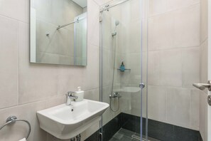Departamento, 1 habitación, cocineta, vista a la ciudad | Baño | Regadera, amenidades de baño gratuitas, secadora de cabello, toallas 