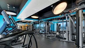 Ein Fitnessstudio mit Laufbändern, Krafttrainingsgeräten und Kurzhanteln.
