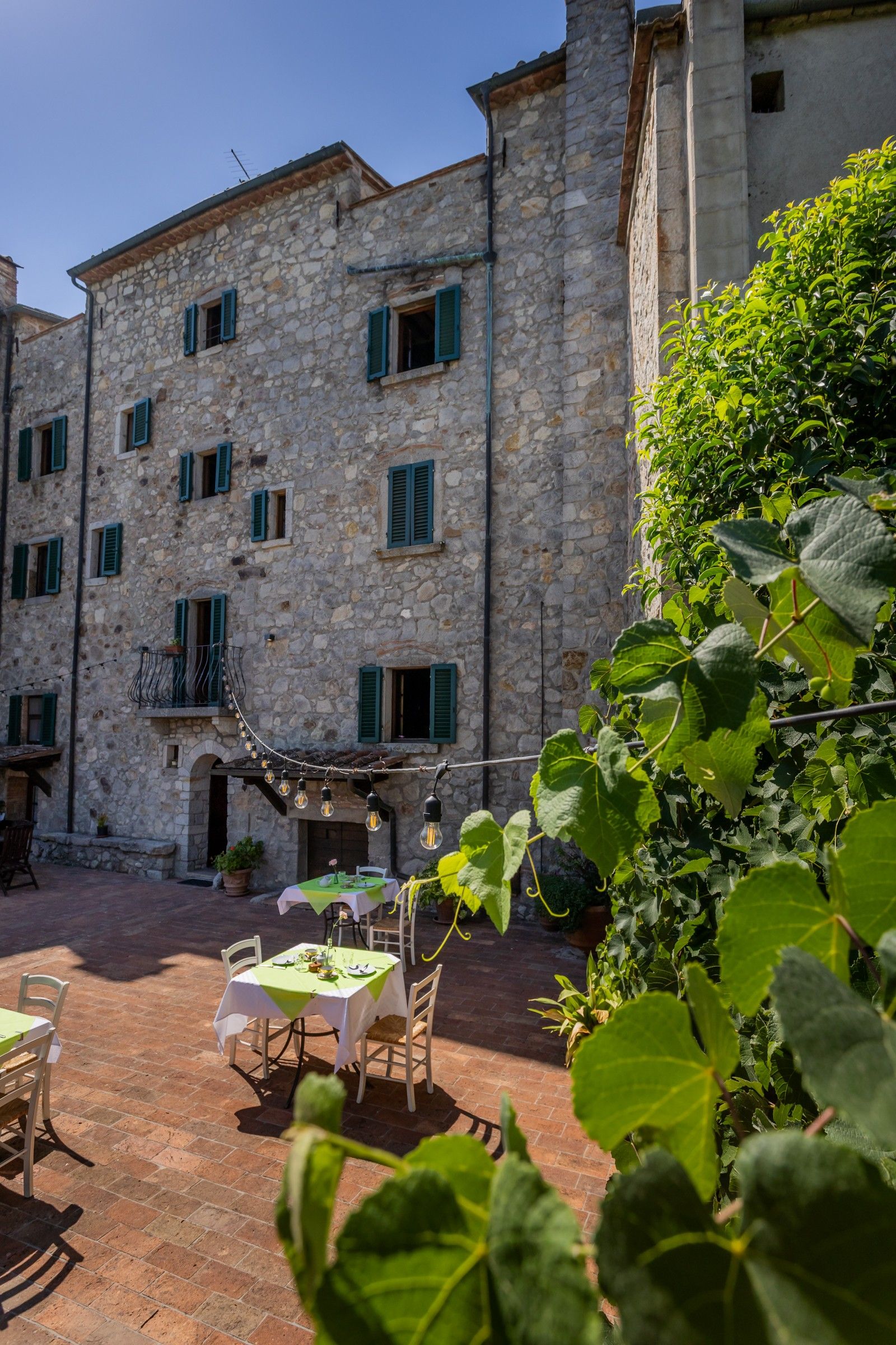 A stone building with multiple windows and a balcony.