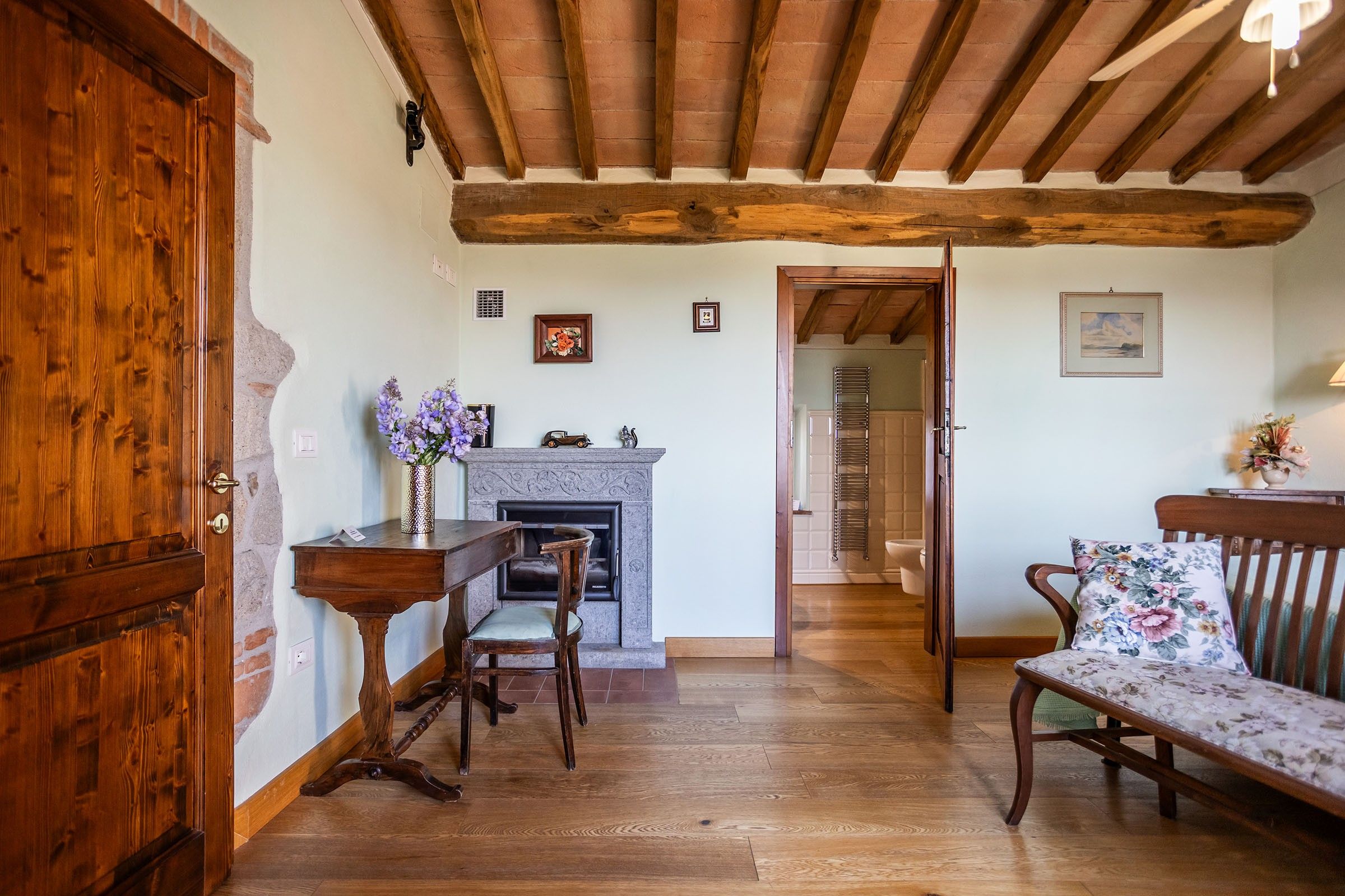 A room with a fireplace, wooden furniture, and a door.