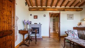 A room with a fireplace, wooden furniture, and a door.