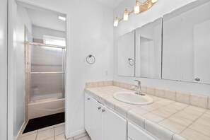 Ein Badezimmer mit Badewanne, Waschbecken, Spiegel und Dusche.