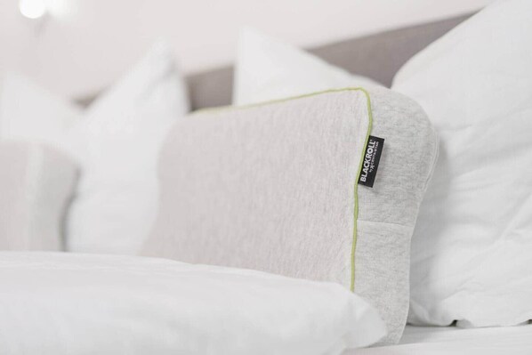 A close-up of a white pillow with a green trim and a Blackroll® tag.