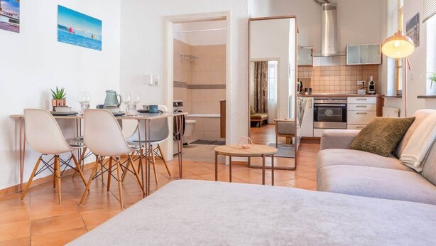 Um apartamento moderno com área de jantar, cozinha e sala de estar.
