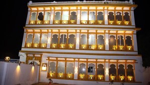 A multi-story building with ornate windows and balconies, featuring traditional architectural elements. - Hotel L S Restaurant & Spa (Udaipur)